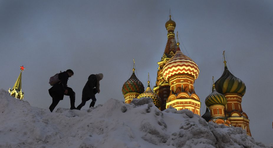 People climb over a snowdrift near St Basil's Cathedral at the Red square after a heavy snowfall in Moscow (Photo: Vasily Maximov/AFP) img
