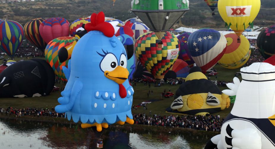 Hot air balloons in the shape of cartoon characters fly during the XV International Balloon Festival (Photo: STR/AFP) img