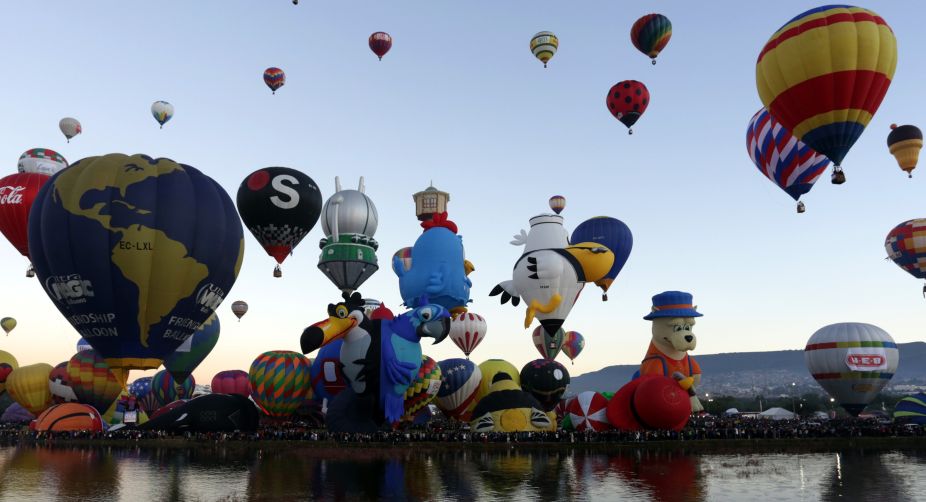 Reflection of the hot air balloons is seen in the water below during the XV International Balloon Festival (Photo: STR/AFP) img