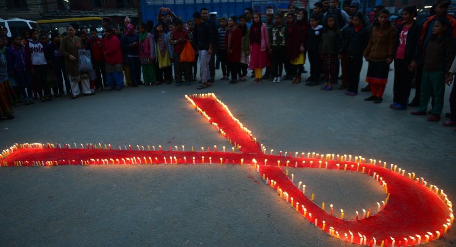Nepalese youth volunteers create a red ribbon, the global AIDS awareness symbol, during an event to mark the eve of World AIDS Day in Kathmandu (Photo: Prakash Mathema/AFP) img