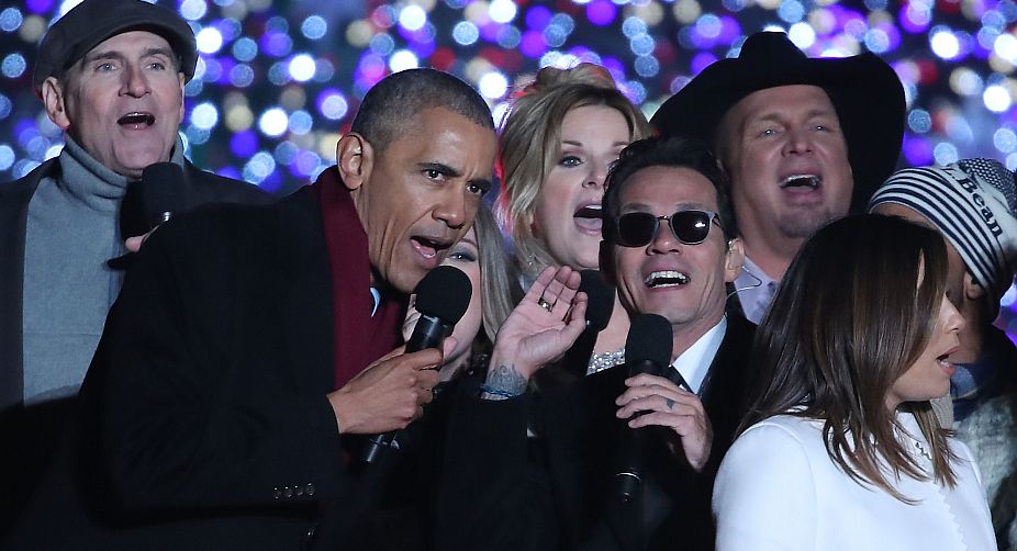 The US President singing jingle bells with Marc Anthony (R) (Photo: AFP) img