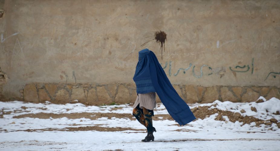 An Afghan woman walks along a street following a snowfall on the outskirts of Mazar-i-Sharif (Photo: Farshad Usyan/AFP) img