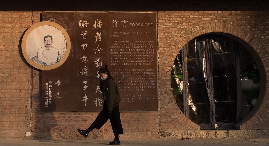 A woman speaks on her phone in the 798 art area in Beijing (Photo: Nicolas Asfouri/AFP) img