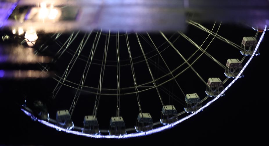 A reflection of a Ferris wheel set up for the Christmas holiday season is pictured in the French Riviera city of Nice, southeastern France (Photo: Valery Hache/AFP) img