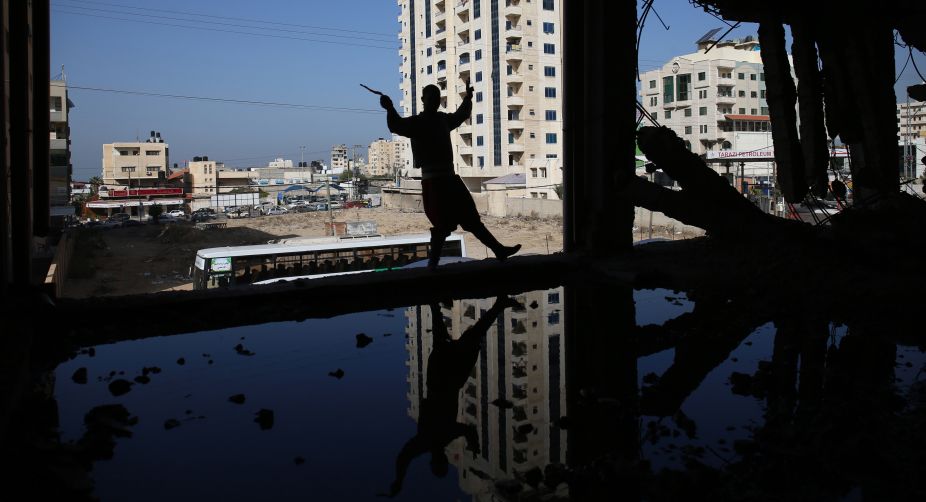 <div>A dancer from the Palestinian Nashama band performs the traditional 'Dabke' inside a building under construction that was damaged during the 50-day war between Israel and Hamas militants during the summer of 2014 in Gaza City (Photo: Mohammed Abed/AFP)</div> img