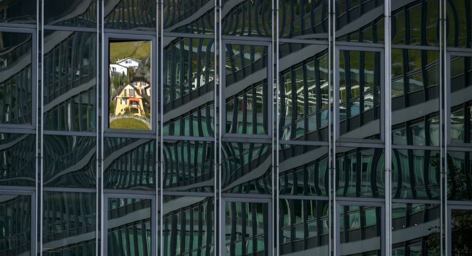 Houses are reflected in a window of a building in Vevey (Photo: Fabrice Coffrini/AFP) img