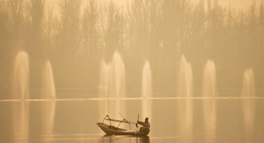 A fisherman rows on his boat during a dense fog day on the Dal Lake in Srinagar (Photo: Tauseef Mustafa/AFP) img