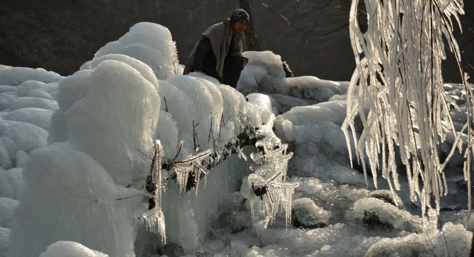 A Kashmiri walks past a frozen body of water in Kokernag (Photo: Tauseef Mustafa/AFP) img
