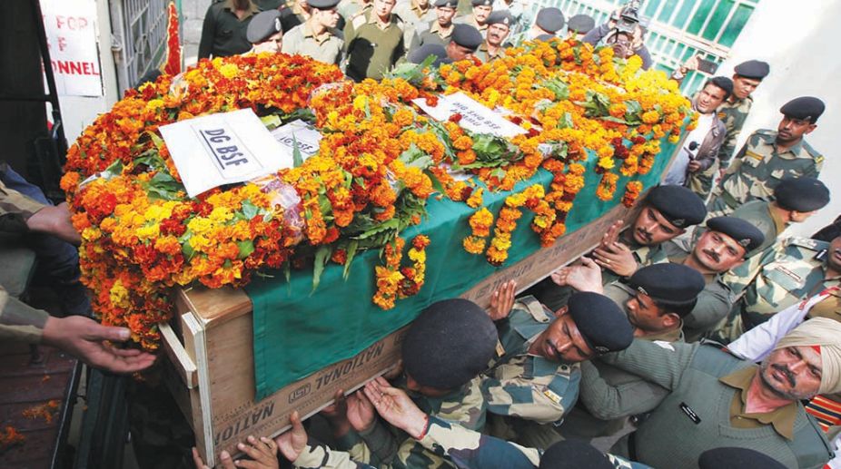 Indian Border Security Force (BSF) officers carry the coffin of slain Head Constable A Suresh during a wreath-laying ceremony at the BSF headquarters in Jammu on January 18, 2018. A BSF personnel died an another sustained injuries while a civilian girl died during shelling at the R S Pura sector along the border with Pakistan. / AFP PHOTO / -