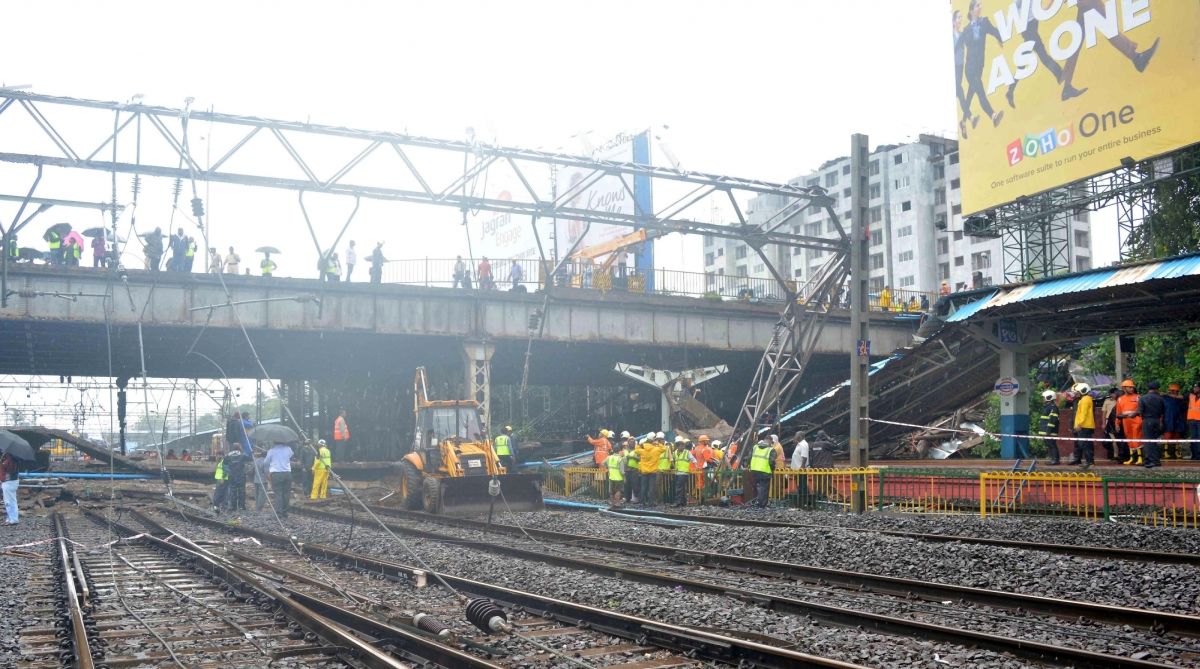 Mumbai: Rescue workers clear the debris after a portion of the Gokhale footover Bridge, running east-west over the Andheri station crashed over the Western Railway (WR) tracks injuring at least three, at Andheri in Mumbai on July 3, 2018. Coupled with torrential overnight rains, the crash severely hit Mumbai's lifeline -- the suburban train services which ferry around eight million commuters daily. (Photo:IANS)