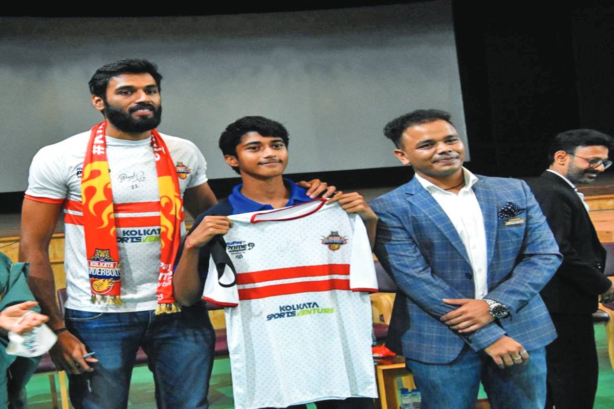 Volley player Ashwal Rai scores a point with school children