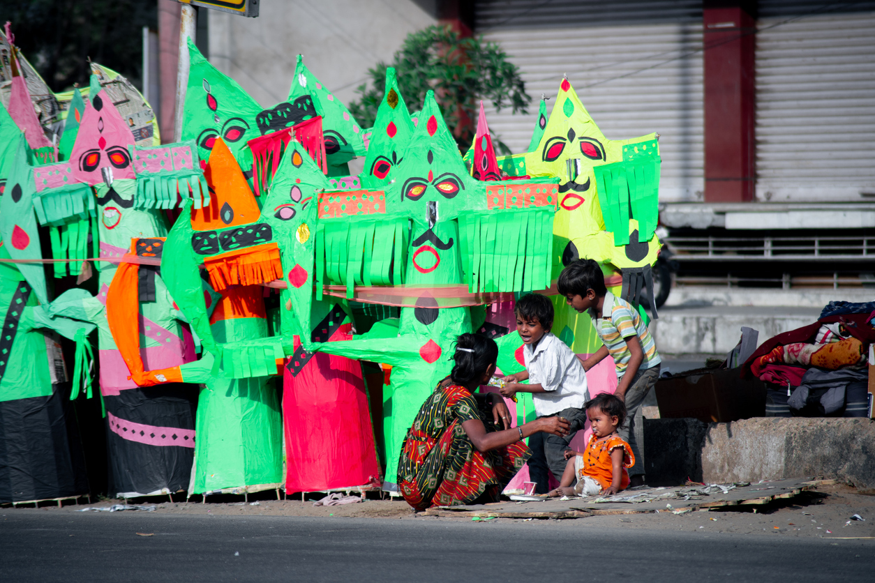 poor poverty stricken migrant artisans sitting on the street side making paper mache effigies of raavan for the hindu festival of dussera post the covid pandemic 