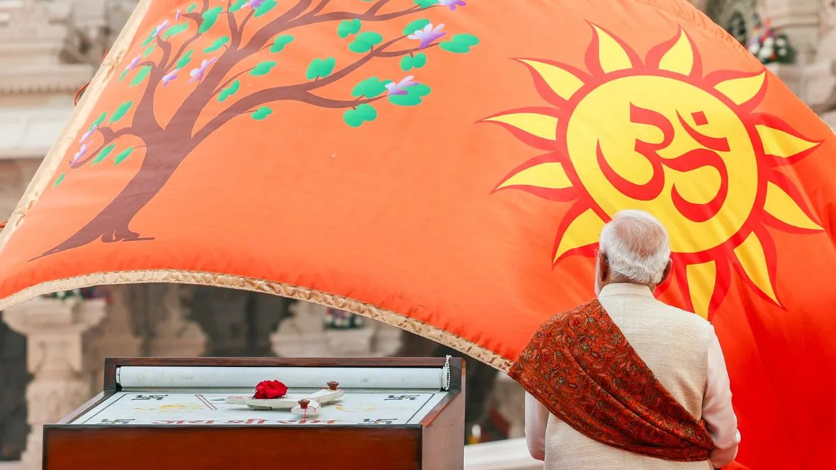 PM Modi stands before the saffron Ram Mandir flag featuring the Sun, Om, and Kovidara tree symbols.