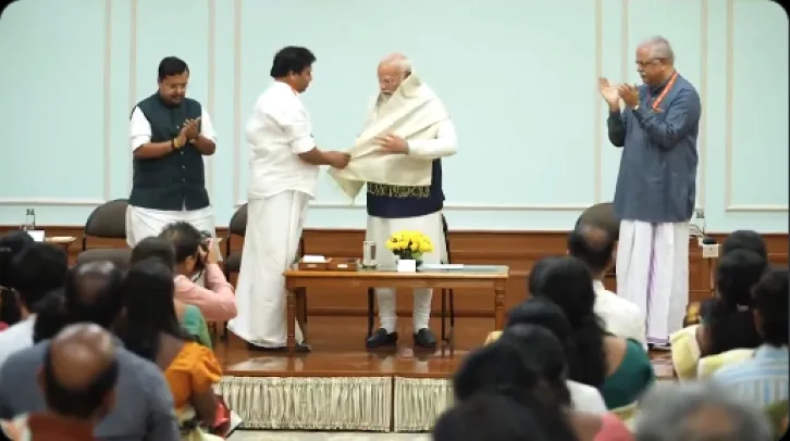One of the newly elected BJP local body representative presents traditional shawl and greetings to PM Modi, marking the significance of their victories. img