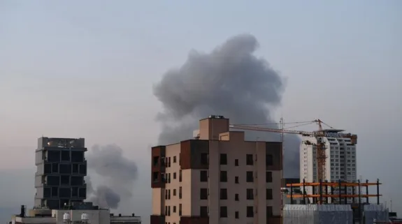 Smoke rises over buildings after reported overnight strikes linked to escalating US-Iran tensions