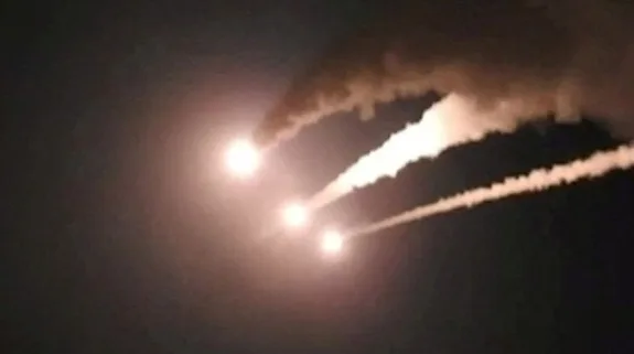 Streaks of light and smoke trails visible in the night sky amid regional military tensions