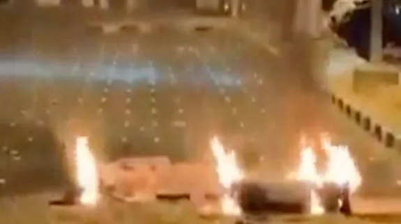 Flames and smoke rise from a damaged area during a nighttime missile attack in the Gulf region