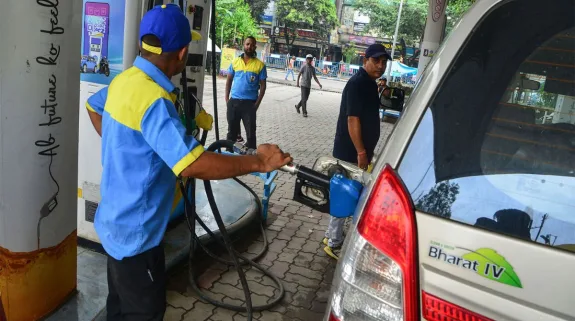 A fuel station attendant fills a passenger car with E20 petrol at an Indian fuel station as the debate over ethanol-blended fuel continues.